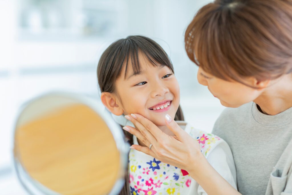 鏡を見ながら笑顔で話す親子